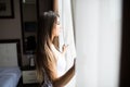 Woman opening window curtains