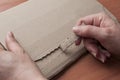 Woman opens a blank cardboard envelope on her desk