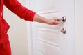 A woman opens the door holding the handle, hand close-up. White woo Royalty Free Stock Photo