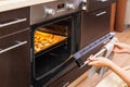 Woman opens the oven where cookies are baked for Halloween Royalty Free Stock Photo