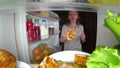 Woman opens the refrigerator at night. night hunger. diet gluttony