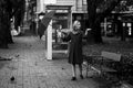 A woman opens an umbrella on the street in the city.