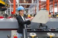 A woman operates industrial equipment inside a busy factory setting, skillfully managing the machinery Royalty Free Stock Photo