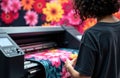 Woman operating fabric printer producing a large bright floral textile roll Royalty Free Stock Photo