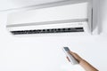 Woman operating air conditioner with remote control indoors, closeup Royalty Free Stock Photo