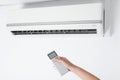 Woman operating air conditioner with remote control indoors, closeup Royalty Free Stock Photo