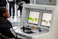 Woman operating x-ray bag scanning security machine