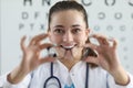 Woman ophthalmologist gives glasses for fitting on background of table for measuring vision
