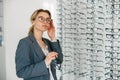 Woman in optic store choosing a new eyeglasses frame. Medical, health care concept