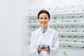 Woman optician holding glasses at optics store