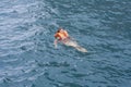 Woman in orange life jacket in water of a sea