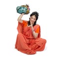 Woman in orange sari sitting and holds turban
