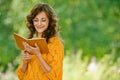 Woman in orange sweater reading Royalty Free Stock Photo