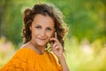 Woman in orange sweater talking on cell phone Royalty Free Stock Photo