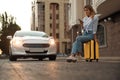 Woman ordering taxi with smartphone on city street