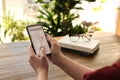 Woman ordering taxi with smartphone at table, closeup Royalty Free Stock Photo