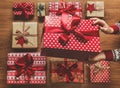 Woman organising beautifully wrapped vintage christmas presents, image with haze, view from above