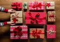 Woman organising beautifuly wrapped vintage christmas presents on wooden background