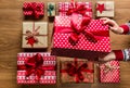 Woman organising beautifuly wrapped vintage christmas presents on wooden background