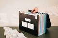 Woman Organizing Documents in a 12-Month Accordion File Organizer