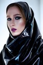 Woman with oriental makeup and black latex hijab