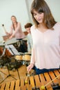 Woman with other musicians playing xylophone