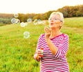 woman outdoor senior elderly happy fun retirement vitality bubble soap blowing active old nature mature Royalty Free Stock Photo