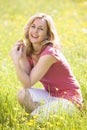 Woman outdoors holding flower smiling Royalty Free Stock Photo