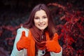 Woman outdoors showing like thumbs up gesture with both hands