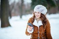 Woman outside in city park in winter using phone applications Royalty Free Stock Photo