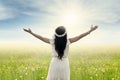 Woman with outstretched hands on meadow