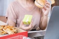 woman over eating fast food burger, pizza and desserts at office desk, Royalty Free Stock Photo