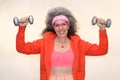 Senior woman working out dumbbells 80s look Sweatband