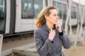 Woman in overcoat walking along a platform at a station Royalty Free Stock Photo