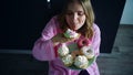 Woman overeat sweet cupcake on kitchen table. Hungry woman eating dessert