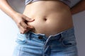 Woman with overweight abdomen. hand holding excessive fat belly. Royalty Free Stock Photo