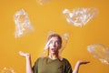 Woman overwhelmed by plastic waste and suffocating from plastic bag over her head - ecology and pollution concept Royalty Free Stock Photo