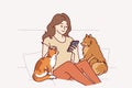 Woman owner of dog and cat sits on couch and plays on phone, enjoying spending time with pets