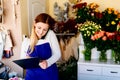 Woman owner of florist shop taking orders Royalty Free Stock Photo