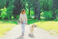 Woman owner walking with her Golden Retriever dog on leash in summer Royalty Free Stock Photo