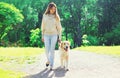Woman owner walking with her Golden Retriever dog on leash in summer Royalty Free Stock Photo