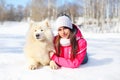 Woman owner with white Samoyed dog lying on snow in winter Royalty Free Stock Photo
