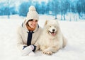 Woman owner with white Samoyed dog lying on snow in winter Royalty Free Stock Photo