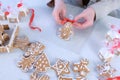 Woman packaging funny gingerbread man cookie with icing for Christmas, top view. Royalty Free Stock Photo