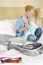 Woman With Packed Suitcase On Bed
