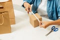 Woman packing cardboard boxes using tape dispenser Royalty Free Stock Photo