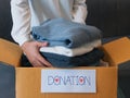 Woman packing clothes into a cardboard box for donation Royalty Free Stock Photo