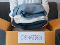 Woman packing clothes into a cardboard box for donation Royalty Free Stock Photo