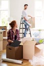 Woman packing stuff into boxes while moving out with husband to Royalty Free Stock Photo