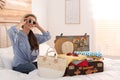 Woman packing suitcase for vacation in bedroom Royalty Free Stock Photo